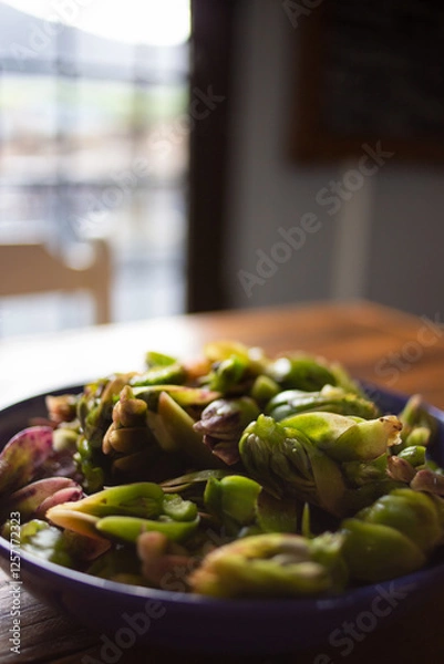 Obraz A bowl filled with freshly harvested waterblommetjies. These edible water lilies, native to the Western Cape, are a key ingredient in Waterblommetjie Bredie, a stew cherished in Cape cuisine.