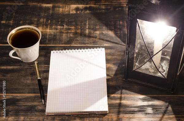 Obraz open notebook on a table with burning candle