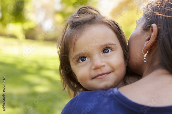 Obraz Mixed race mother holding her daughter, over shoulder view