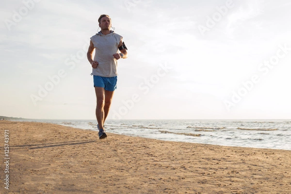 Obraz Handsome man running along the coast line