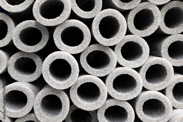 Fototapeta Stacks of grey foam insulation tubes for pipes