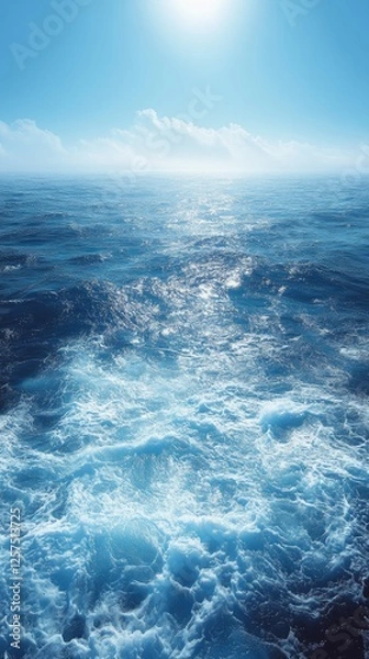 Obraz Serene ocean waves glistening under a bright sun with distant clouds on a clear day