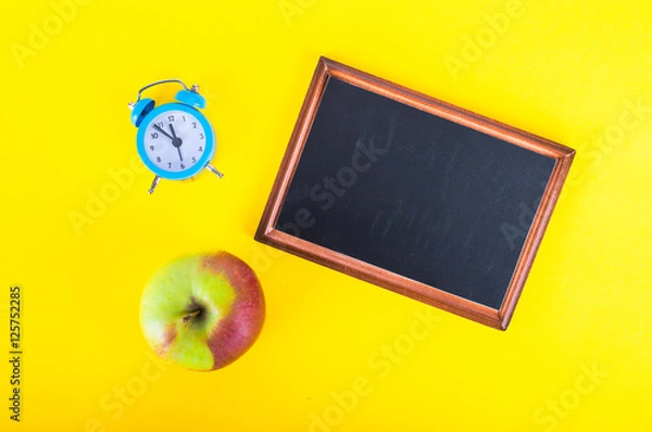 Obraz Blackboard, an apple and an alarm clock. Time to eat. On a yellow background.