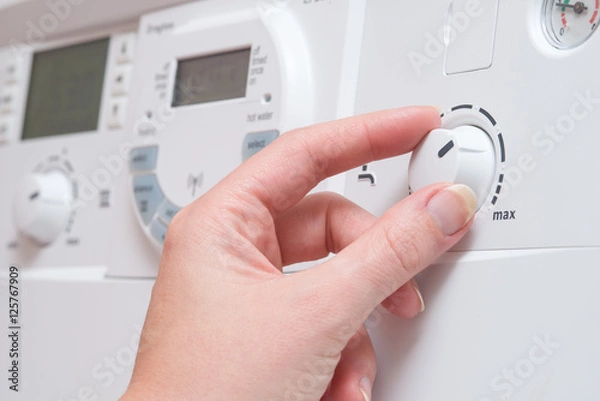 Obraz Hand Adjusting Hot Water Dial on Boiler