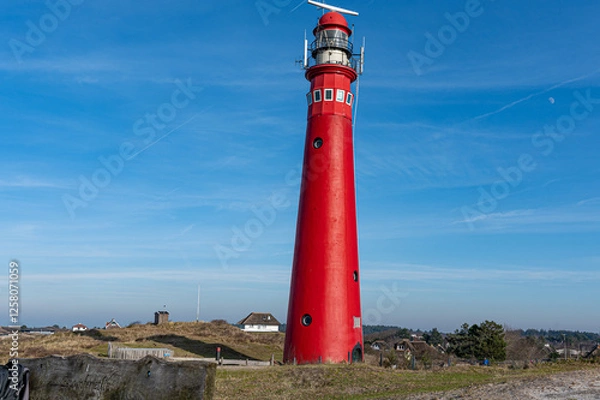 Fototapeta The red lighthouse on Schiermonnikoog. The sky is blue and clear. There are no clouds in the sky in the Wadden Sea