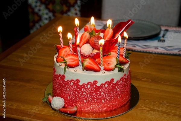 Fototapeta Birthday cake with strawberries and candles on the table. Selective focus.