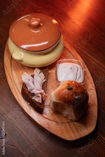 Fototapeta Restaurant dish borscht, delicious bread with bacon, sour cream, bun. A delicious photo for a menu, culinary website, or an advertisement for catering establishments.
