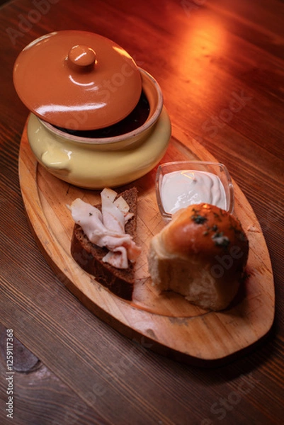 Fototapeta Restaurant dish borscht, delicious bread with bacon, sour cream, bun. A delicious photo for a menu, culinary website, or an advertisement for catering establishments.