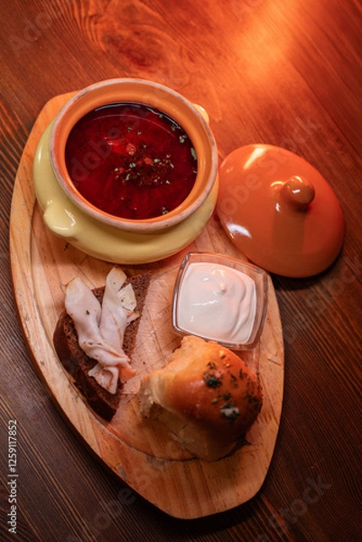 Fototapeta Restaurant dish borscht, delicious bread with bacon, sour cream, bun. A delicious photo for a menu, culinary website, or an advertisement for catering establishments.