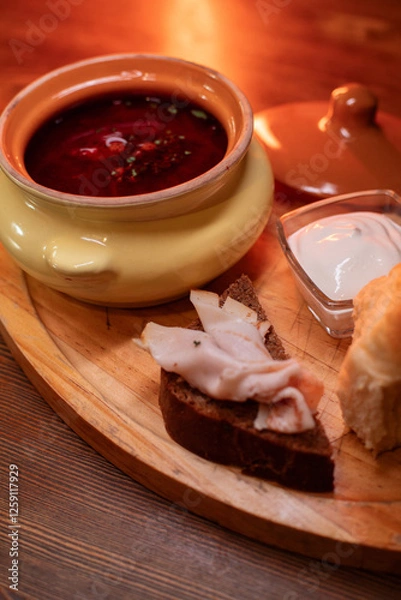 Fototapeta Restaurant dish borscht, delicious bread with bacon, sour cream, bun. A delicious photo for a menu, culinary website, or an advertisement for catering establishments.