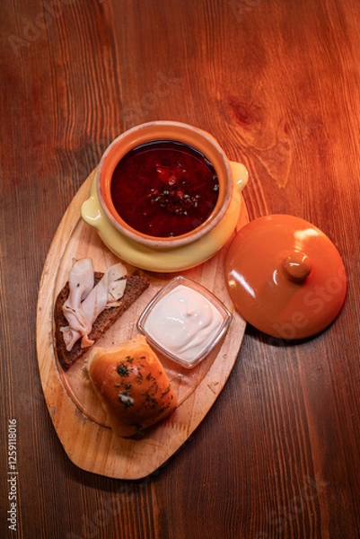 Fototapeta Restaurant dish borscht, delicious bread with bacon, sour cream, bun. A delicious photo for a menu, culinary website, or an advertisement for catering establishments.
