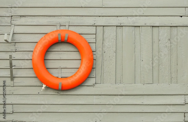 Fototapeta orange lifebuoy hanging on gray wooden wall background