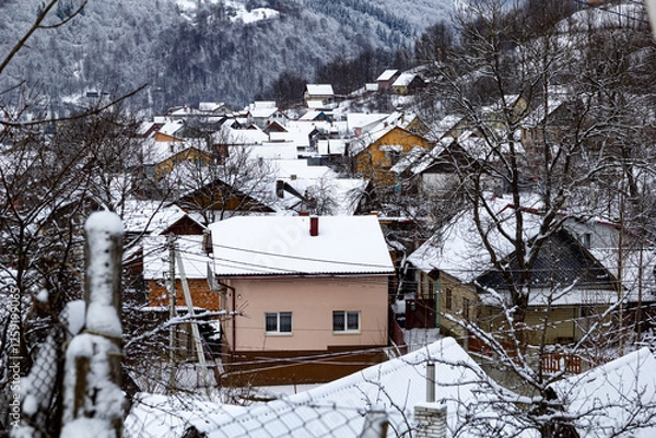 Obraz A lot of colorful houses in snowy mountains during winter, surrounded by snow-covered trees. A peaceful countryside scene