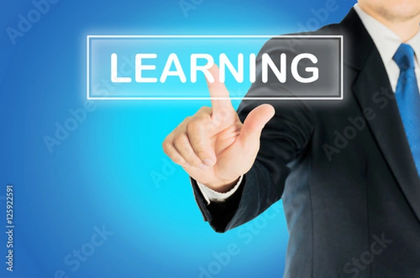 Fototapeta Business man is pushing LEARNING transparent button word over blue gradient background, business concept