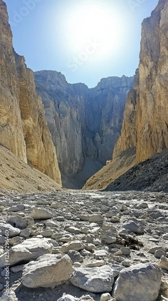 Fototapeta Majestic canyon with towering cliffs under bright sun, showcasing rugged terrain and shadows