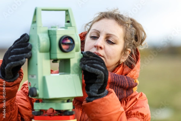 Fototapeta Девушка геодезист работает с тахеометром
