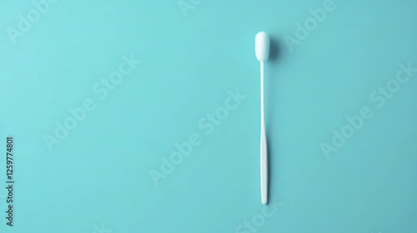 Fototapeta cotton swab lies on solid teal background, showcasing its simple design and functionality. This captures essence of everyday hygiene products in clean and minimalistic way