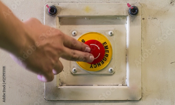 Fototapeta pushing emergency red stop button.
