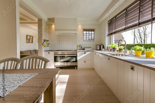 Fototapeta A modern kitchen with a spacious dining area and large windows overlooking a garden.