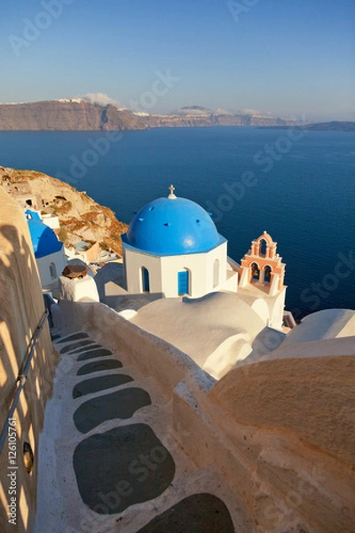 Fototapeta Red belled church in Oia, Santorini at daylight. Stairs way on f