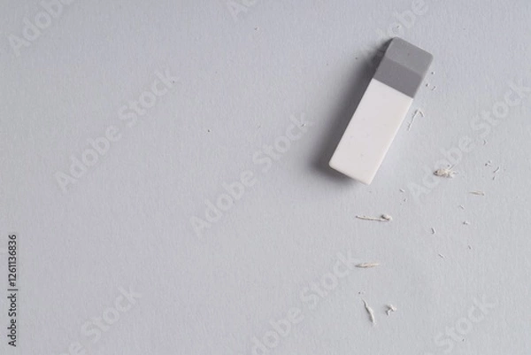 Fototapeta One eraser and scraps on grey background, top view. Space for text