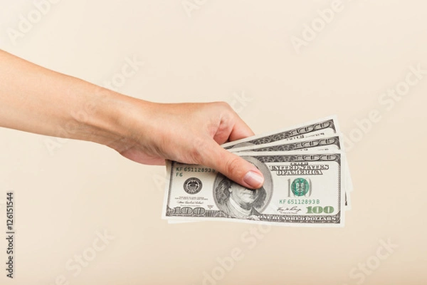 Fototapeta Woman's hand with money on a light background