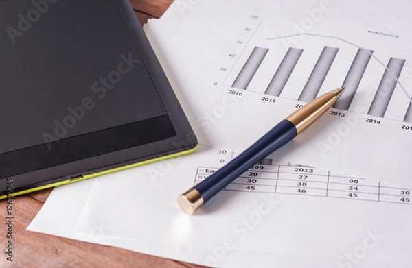 Obraz The tablet and pen on the business papers.