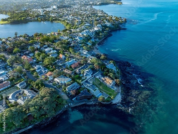 Fototapeta Coastal suburbia, stunning homes, and a tranquil bay. Aerial view of waterfront properties. TAKAPUNA, AUCKLAND, NZ