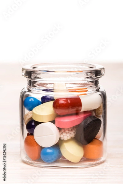 Obraz Colored pills in transparent glass container