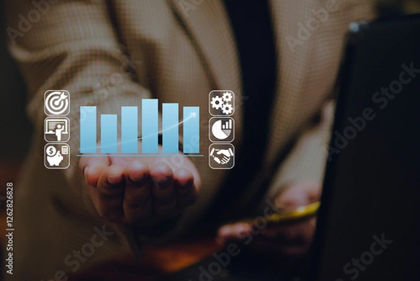 Fototapeta A business person or entrepreneur holds a holographic bar chart with financial and business icons, symbolizing budget planning, financial growth, and strategic investment management.