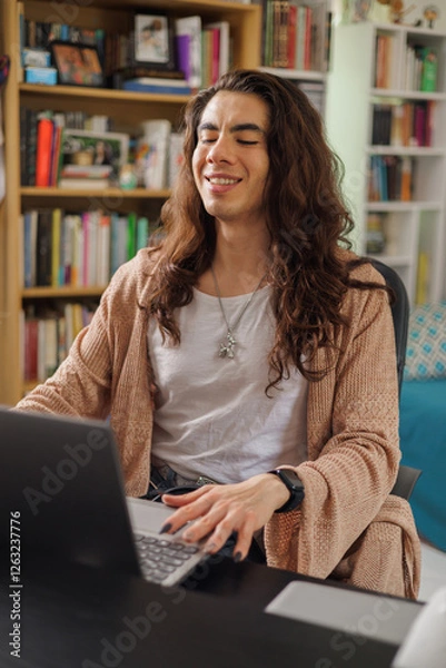 Fototapeta Non-binary person wearing glasses working from home