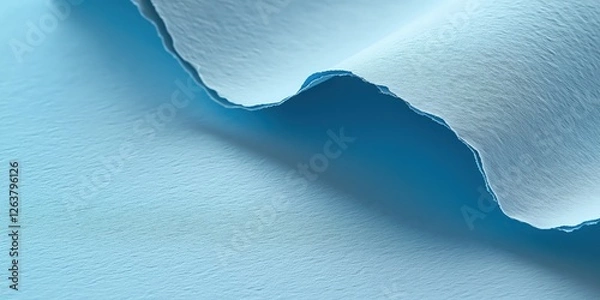 Fototapeta A close-up captures a serene, light blue, textured expanse bisected by a gracefully arched crack. Shadows subtly highlight its depth on one edge, enhancing its allure