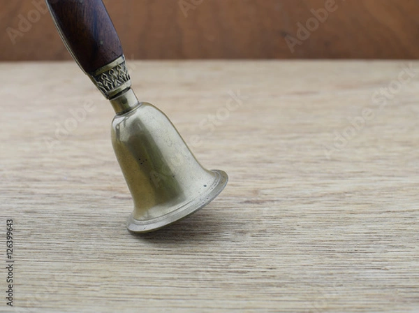 Obraz Ancient bronze bell on wood background