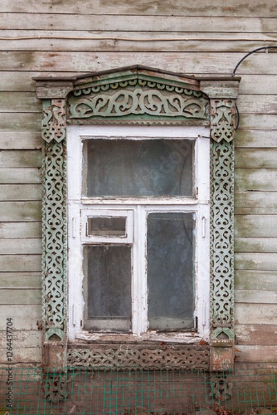 Fototapeta Window of an old wooden house with carved frames