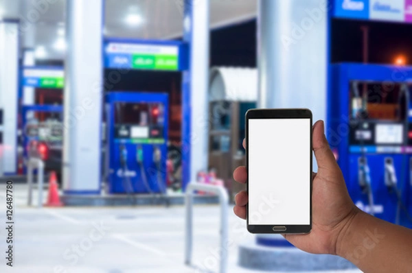 Fototapeta the hand of man hold mobile phone over blurred car .filling stat