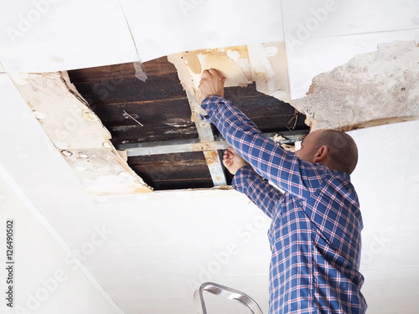 Obraz Man repairing collapsed ceiling.