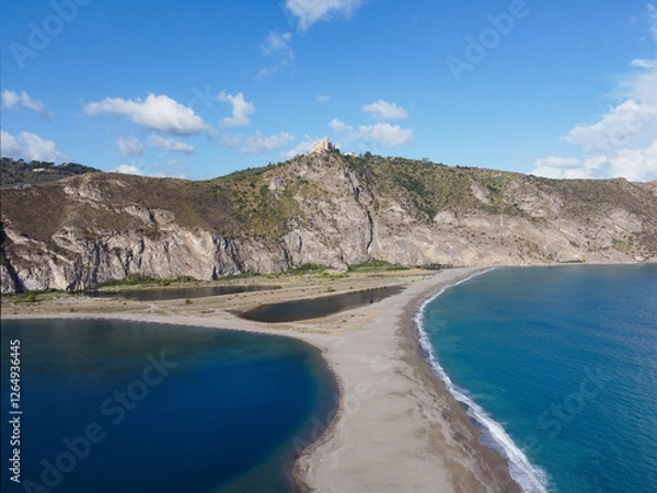 Fototapeta Aerial drone view of Laghetti di Marinello, natural reserve in Sicily, Italy. Sand strip with crystal clear turquoise lagoons, lush Mediterranean vegetation, below a cliff and Tindari Sanctuary.