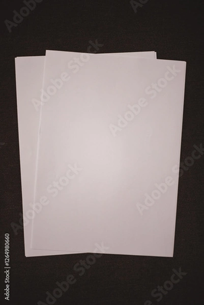Obraz Mockup white sheets of paper on a dark brown background. Empty sheets of paper for your design.