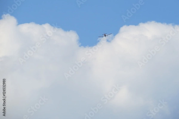 Obraz Small airplane passing in a fluffy cloud.