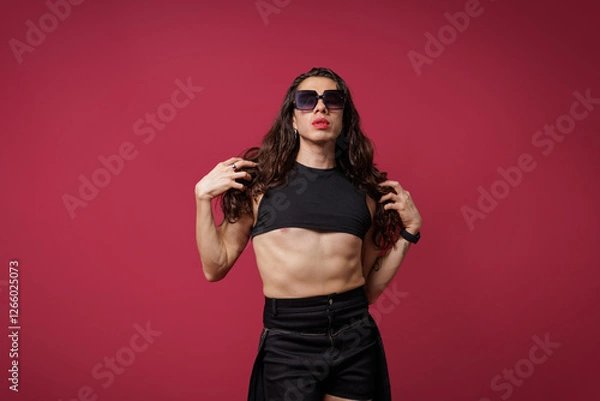 Fototapeta non-binary person is posing on a red studio background Man has an artistic expression. Concept of non-binary people. pride
