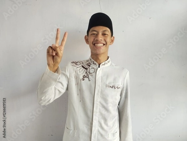 Fototapeta Moslem Asian man smiling at the camera and showing two fingers