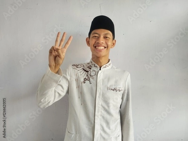 Fototapeta Moslem Asian man smiling at the camera and showing three fingers sign