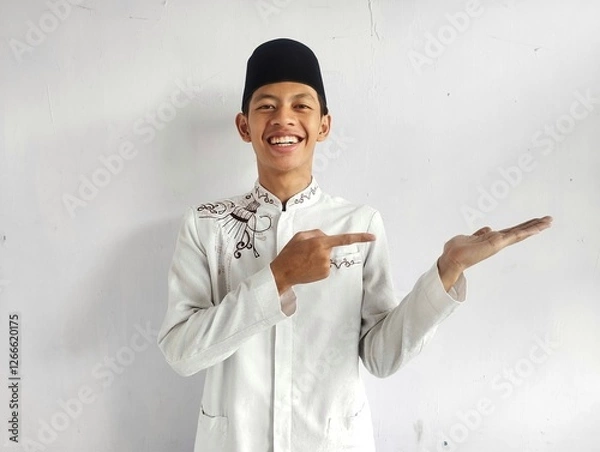 Fototapeta A muslim man smiling happy with one hand holding invisible object