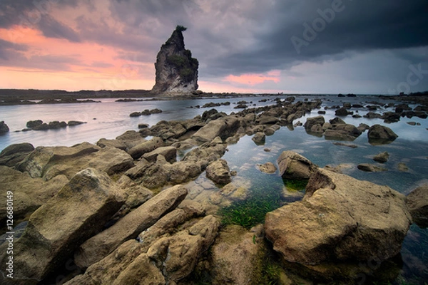 Obraz Beautiful seascape scenery of big boulder stone with small rock foreground at Sawarna beach, Banten, Indonesia