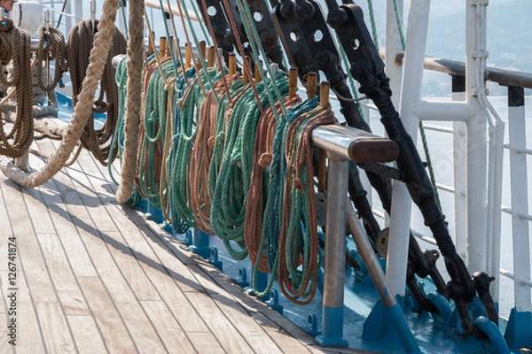 Fototapeta Deck and ropes, rigging on a wooden tall ship sail yacht. Close up view