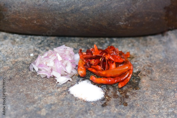 Fototapeta Traditional Sri Lankan way of grinding spices with the grinding stone. Before the electric blenders, the spices were painstakingly ground manually in all houses in Sri Lanka with the grinding stone
