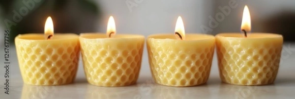 Fototapeta Four candles burn brightly in a straight line on a wooden table, creating a warm and inviting ambiance.