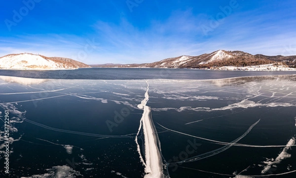 Fototapeta Aerial top view to Blue clear ice lake Baikal. Crack covered snow on frozen water surface. Cold winter landscape with mountains, sunny day, Natural background. , Russia, Siberia.