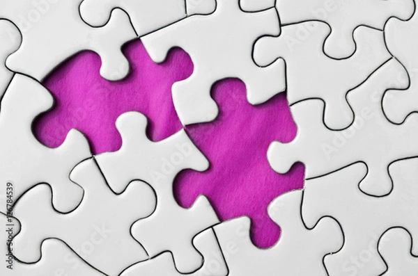 Fototapeta A top view image of a white jigsaw puzzle with a missing puzzle piece.