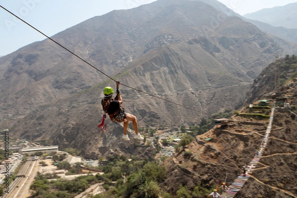 Fototapeta mujer haciendo deporte extremo canopy en la montaña con accesorios de seguridad y casco color verde